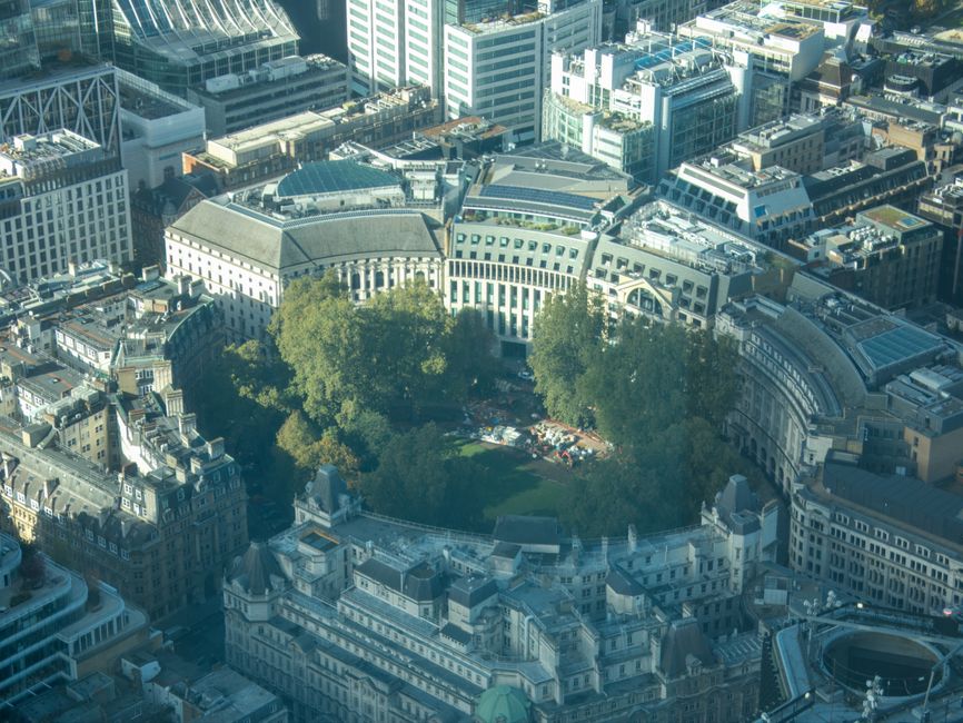 An aerial view of the Tower of London surrounded by dense urban cityscape with modern high-rise buildings and historic architecture. The historic fortress's stone walls and turrets are visible, with green trees lining the inner courtyard area. The surrounding streets are filled with traffic and the city appears vibrant under clear daylight, highlighting the contrast between the historic site and contemporary city structures. This image emphasizes the blend of history and modern development in central London, as seen from a high-angle perspective. Carpet Cleaning Finsbury Park offers surface cleaning and deep cleaning services to maintain the hygiene and appearance of homes and commercial spaces, similar to the city's efforts to preserve its historic sites and urban environment.